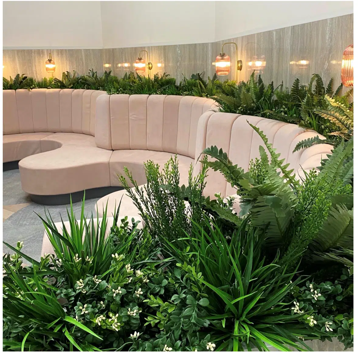 Installation de plantes artificielles autour d'un coin salon dans un lieu d'accueil