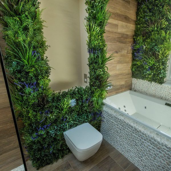 Artificial green wall around toilet in bathroom