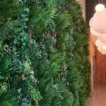 A narrow hallway showcases the Trailing Ivy Texture Box on the left wall, creating a lush vertical garden. On the right, round white pendant lights hang elegantly above, illuminating the space below.