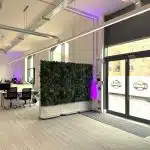 A modular artificial green wall partition at the entrance to an office building