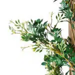 A close-up of the lush and elegant Extendable Artificial Trailing Foliage showcases green leaves with small white flowers on a wooden trellis against a white backdrop.