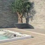 A realistic 6ft fake olive tree installed in a garden
