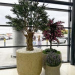 A tall artificial olive tree in a pot