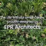 Lush green plants densely cover the vertical surface, with various ferns and foliage. Overlaid text reads: The Life Without Limits Centre, proudly designed by EPR Architects in London, also home to The RSBC Headquarters.