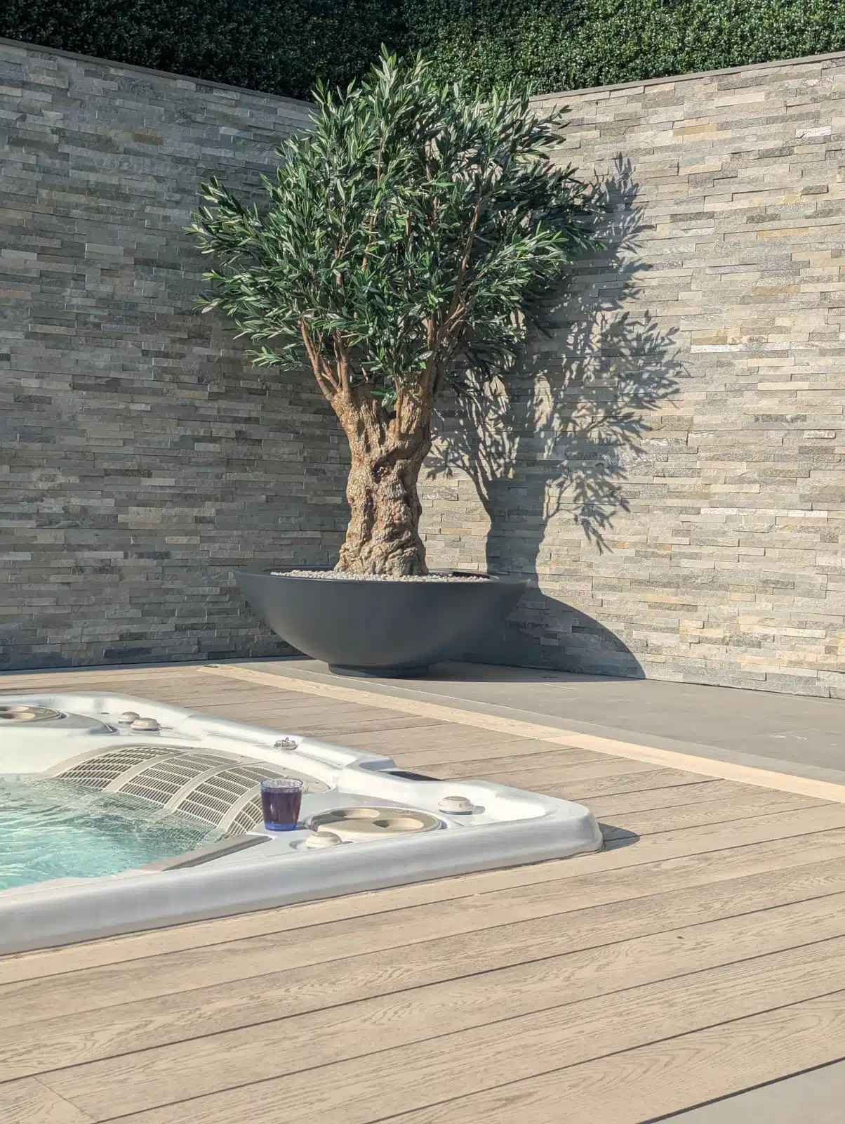 An artificial olive tree installation in a garden