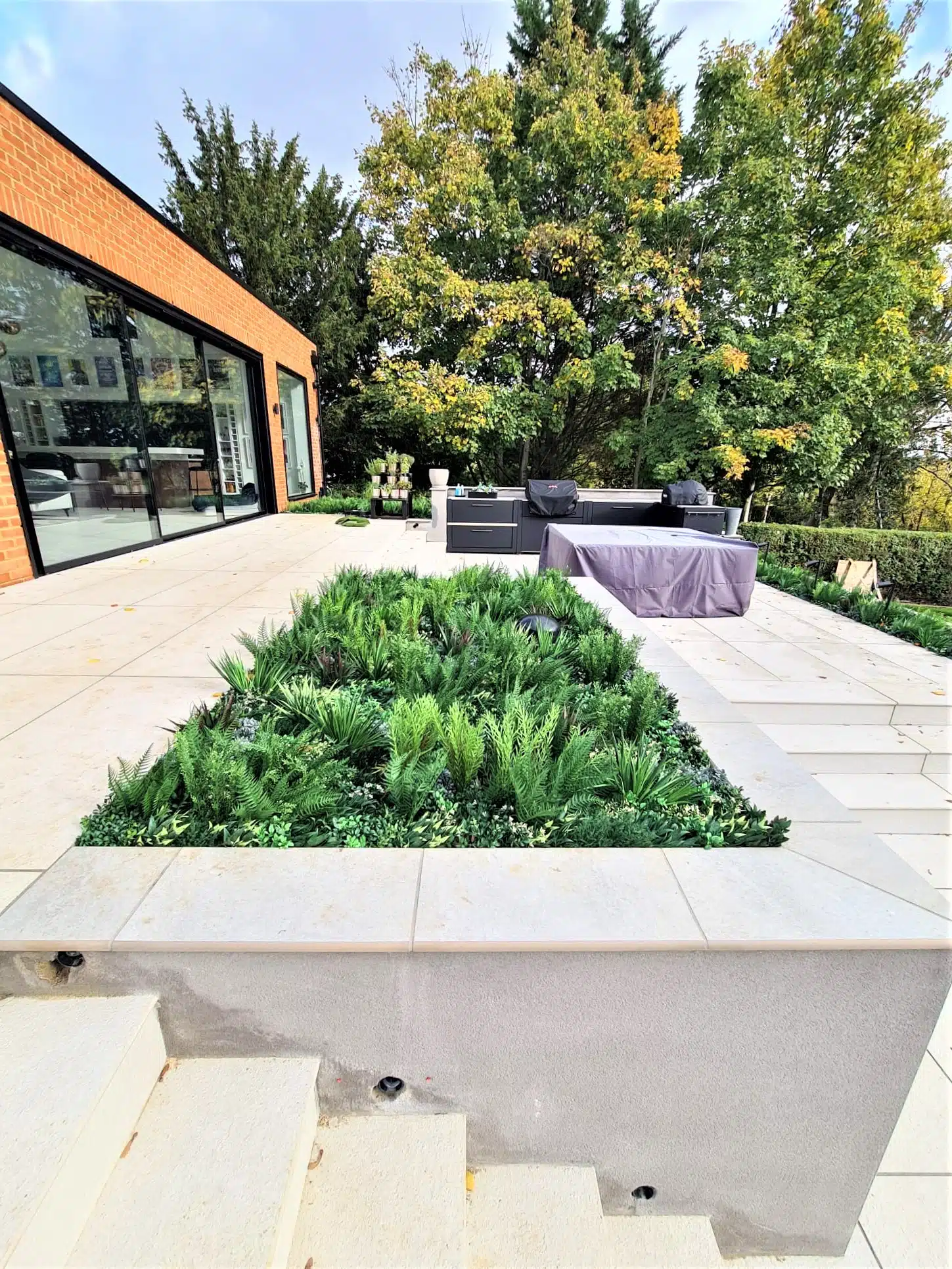 artificial plants installed into a planter in a garden in London