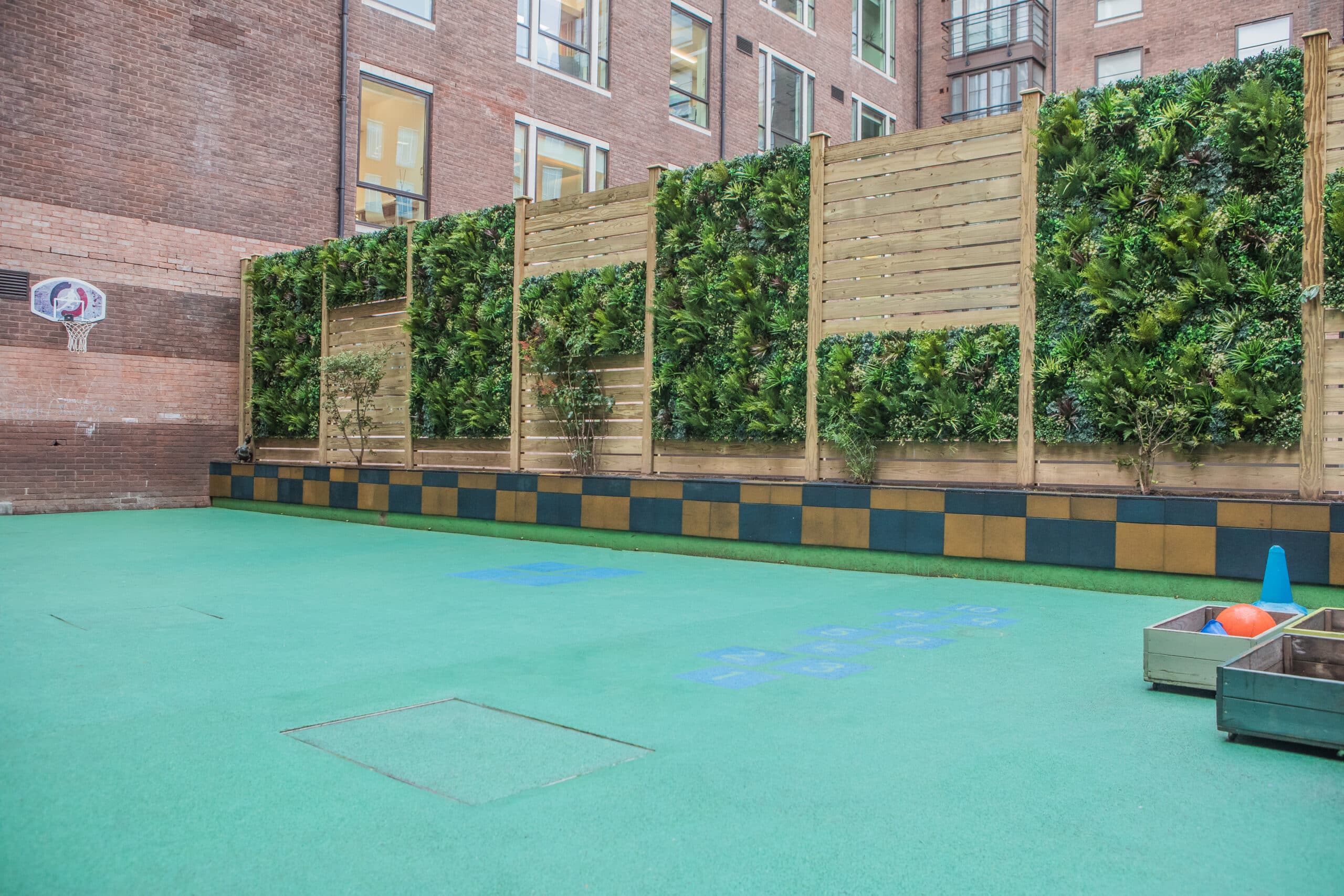 an artificial green wall installation on a privacy screen in a school