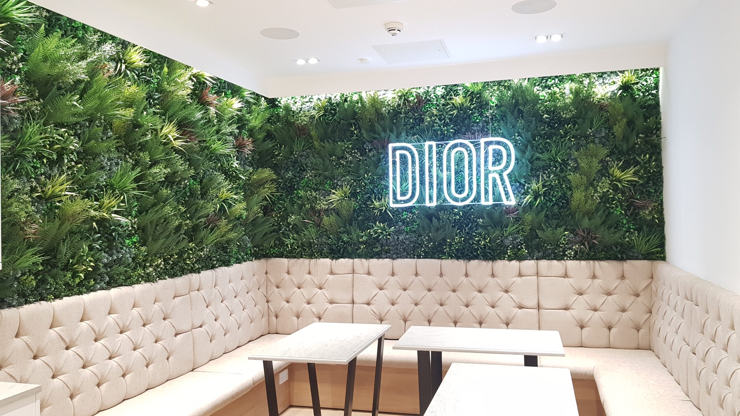 Installation d'un mur végétal artificiel dans un espace de détente avec le logo Dior.