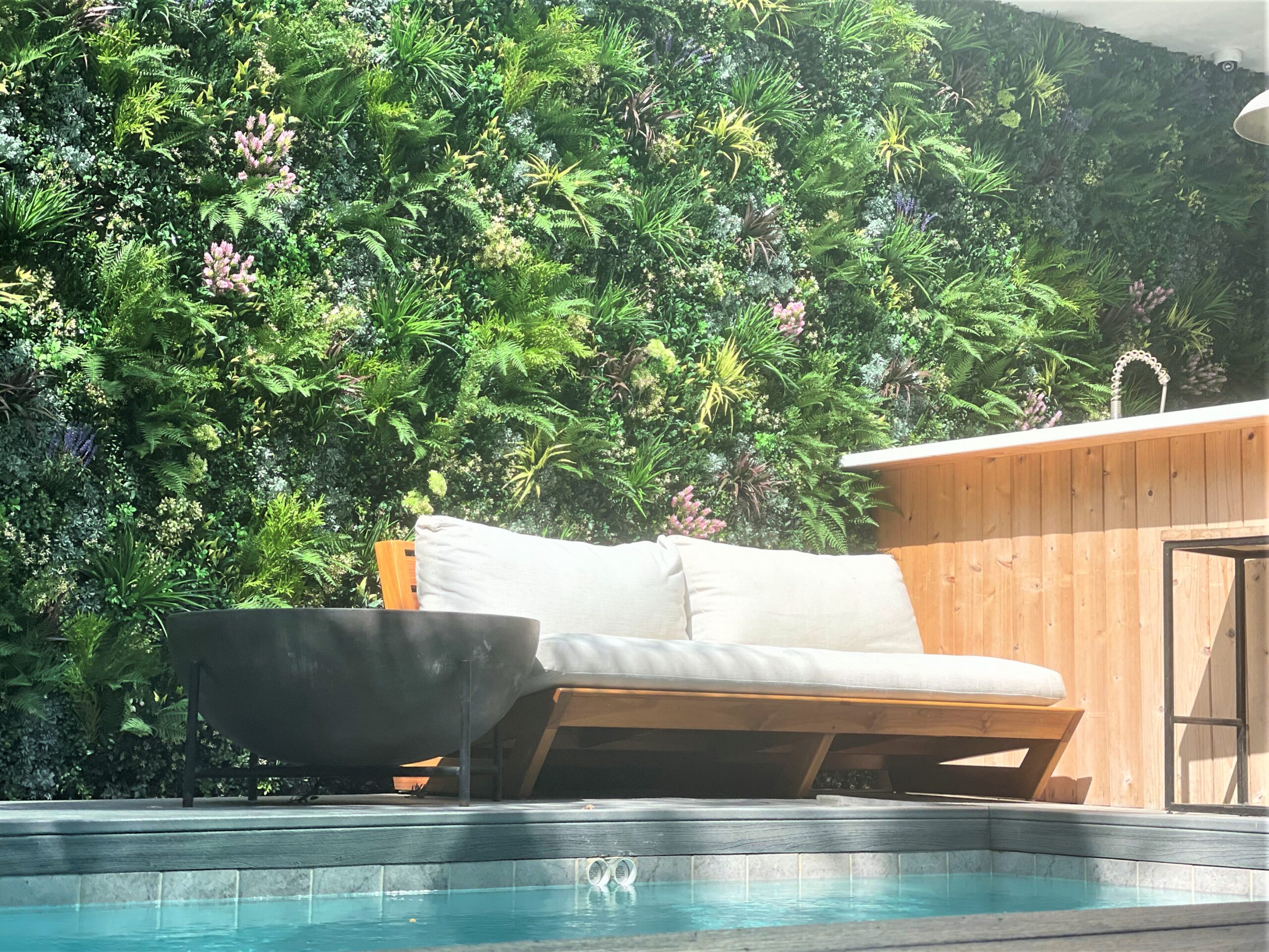 Mur végétal artificiel au bord d'une piscine dans une arrière-cour en Californie
