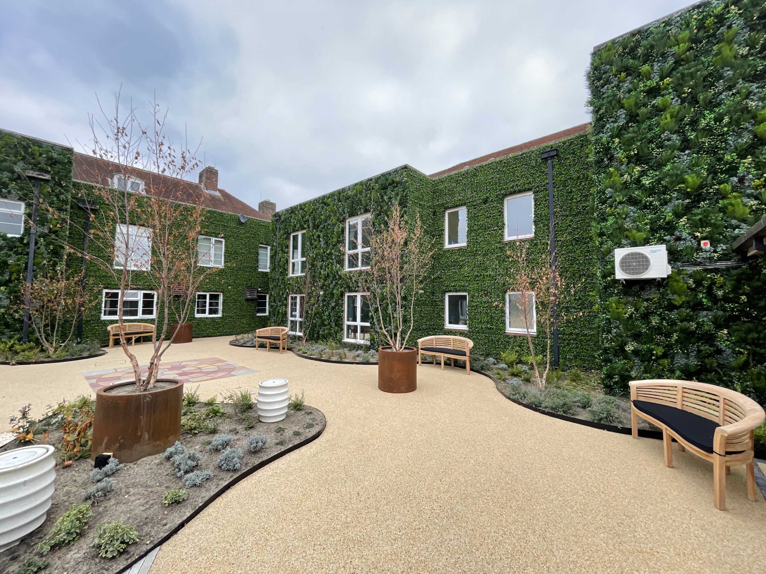 An artificial grass wall installed on a building facade in a courtyard