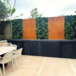 Installation d'un mur végétal artificiel utilisant des panneaux Vistafolia Essence parmi des panneaux en Corten.