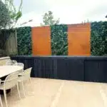 Installation d'un mur végétal artificiel utilisant des panneaux Vistafolia Essence parmi des panneaux en Corten.
